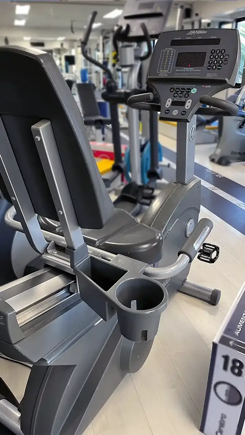 Imagen de cicloergómetro con respaldo y sensores para ejercicio cardiovascular seguro en centro de kinesiología KinesicWork en La Reina