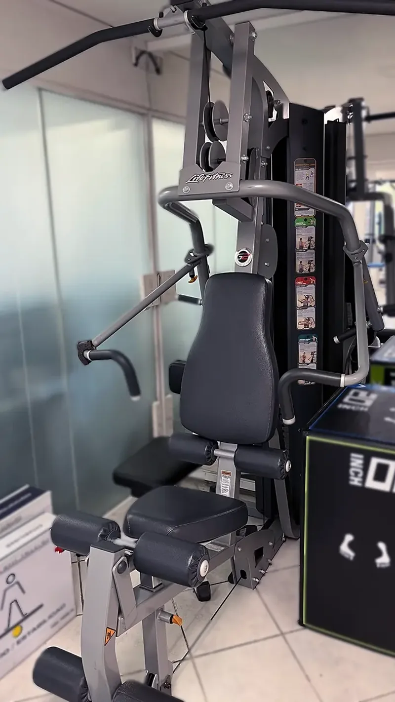 Imagen de estación de entrenamiento versátil con torre de pesas en centro de kinesiología KinesicWork, usada en rehabilitación integral