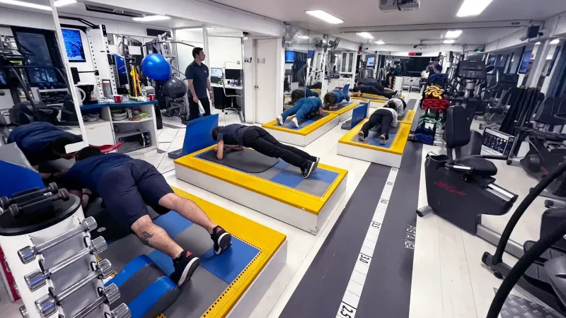 Equipo de kinesiólogos realizando planchas en grupo durante una pausa activa en el centro de rehabilitación
