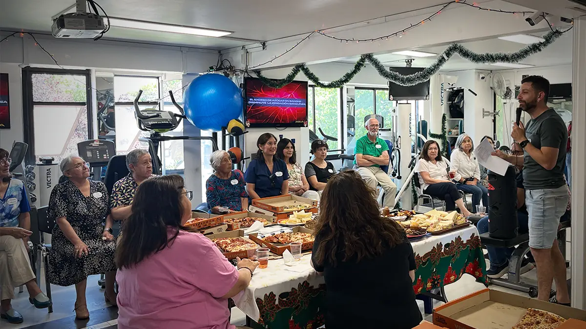 Álvaro, kinesiólogo de KinesicWork, animando la celebración con micrófono frente a los pacientes